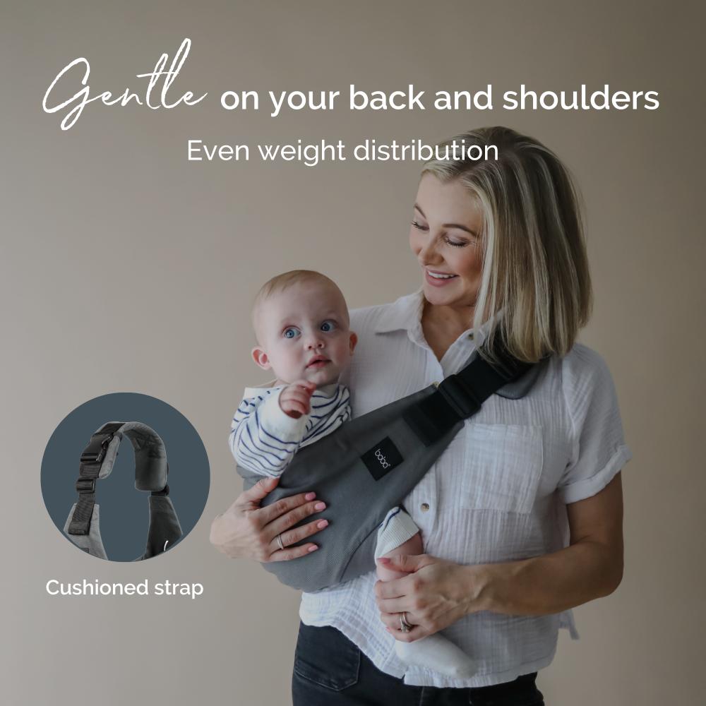 Woman holding a baby using a hip toddler sling carrier with text about even weight distribution and cushioned strap.