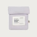 A folded light lavender bottom sheet with a white paper label reading 'babu basics. bottom sheet' and a small side tag, shown on a plain light gray background.