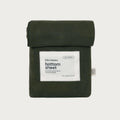 An olive green folded cotton bottom sheet with a white paper label reading 'babu basics. bottom sheet' on a light gray background.
