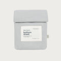 A light gray cotton bottom sheet by babu basics, neatly folded and packaged in a matching light gray sleeve with a white label on the front.
