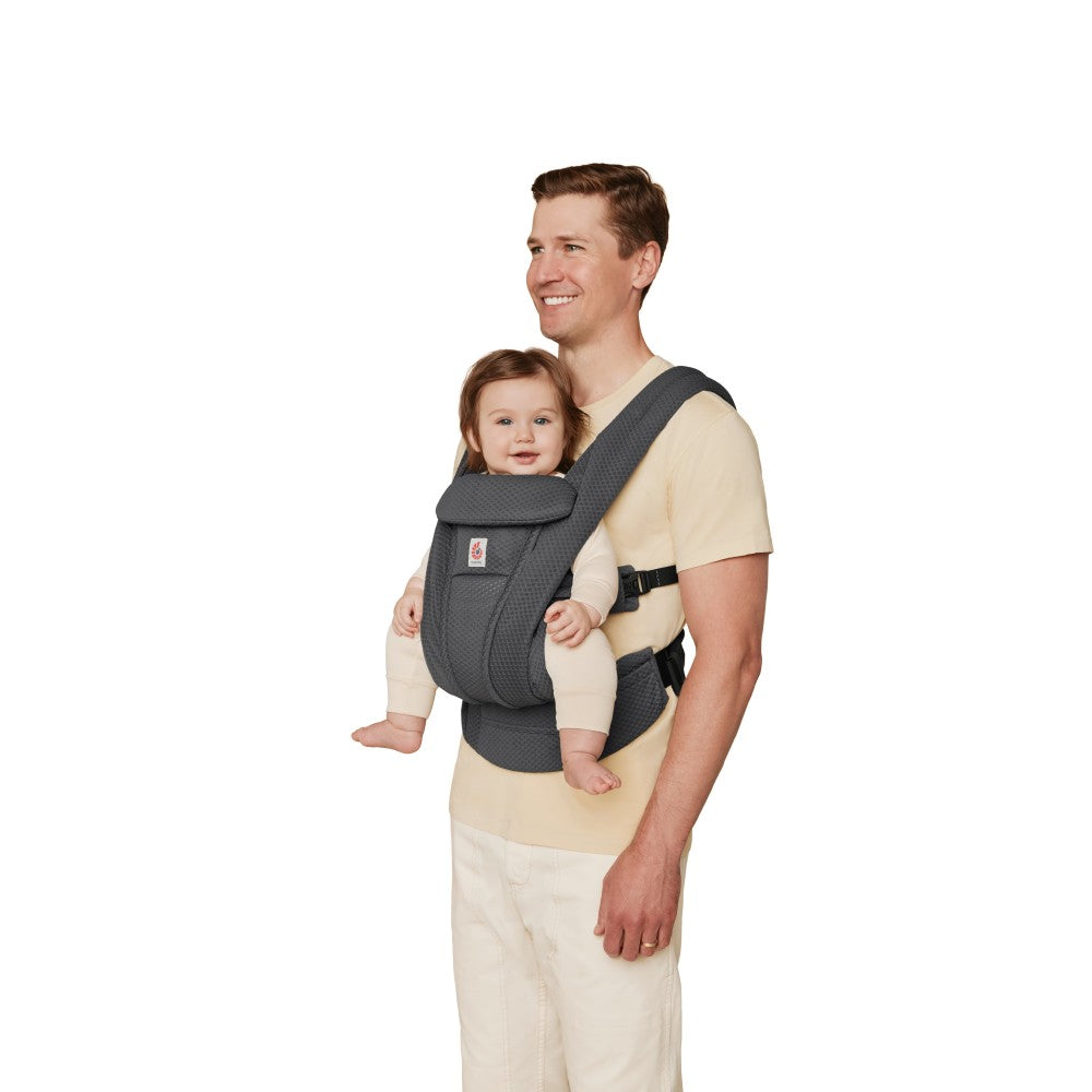 Man carrying a baby in a gray ergonomic carrier on a white background
