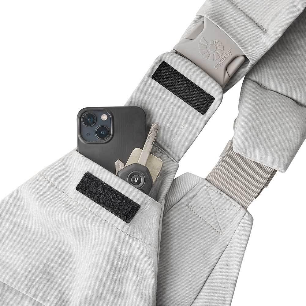 A light gray toddler hip carrier with an adjustable shoulder strap and buckle, shown against a plain white background.