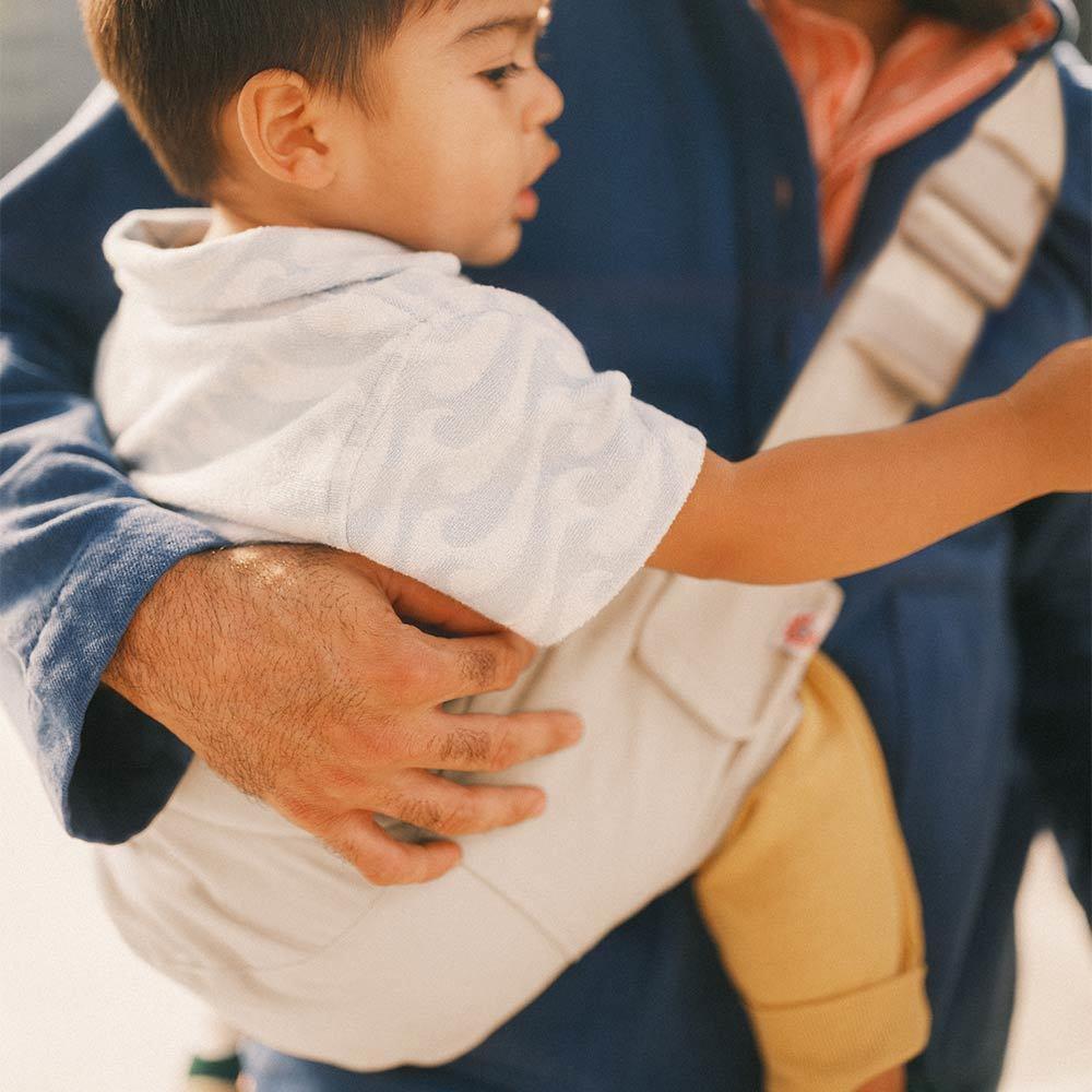 Child being held by an adult with a blurred background