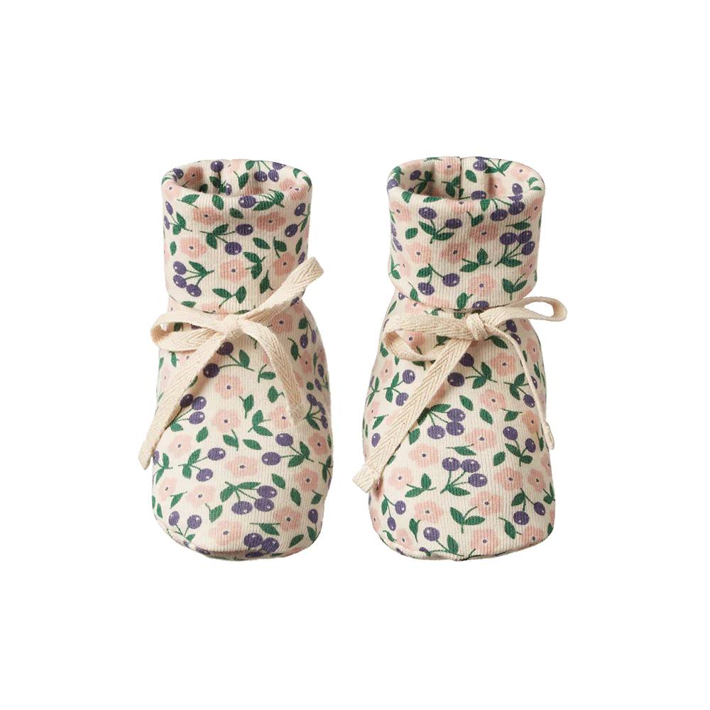 Pair of organic cotton cream and pink/purple/green floral baby booties with calico bows on a white background