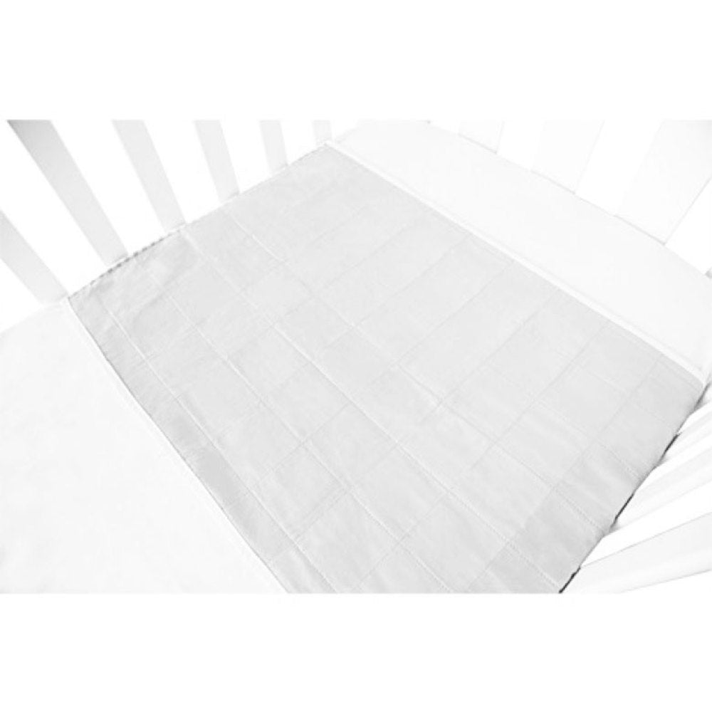 A white quilted mattress protector brolly sheet cot pad laid over a white mattress inside a white crib, shown from an overhead angle.