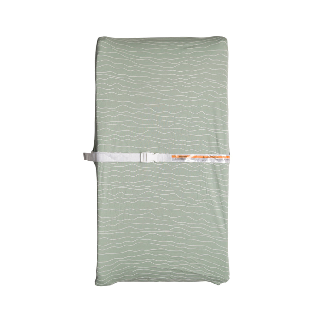 Green change mat cover on a change pad on a white background