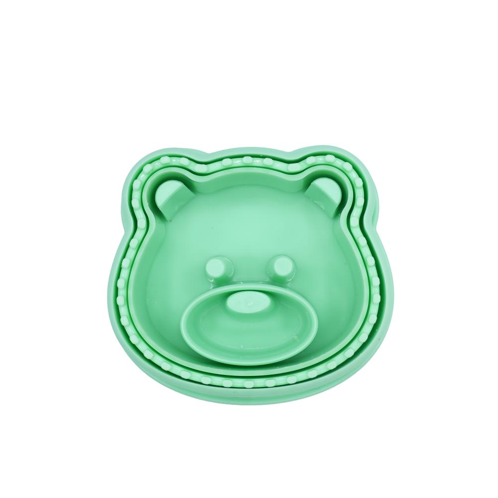 Set of green bear-shaped cookie cutters on a white background