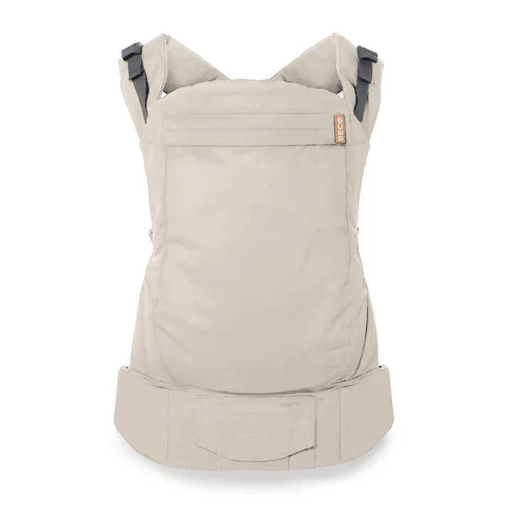 Atoddler and child carrier backpack in a light beige fabric, shown from the back on a clean white background. The carrier features dark gray adjustable shoulder straps and a small tan brand label on the upper right side.