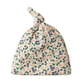 Cream, purple, green and pink Floral patterned baby hat with top knot on a white background