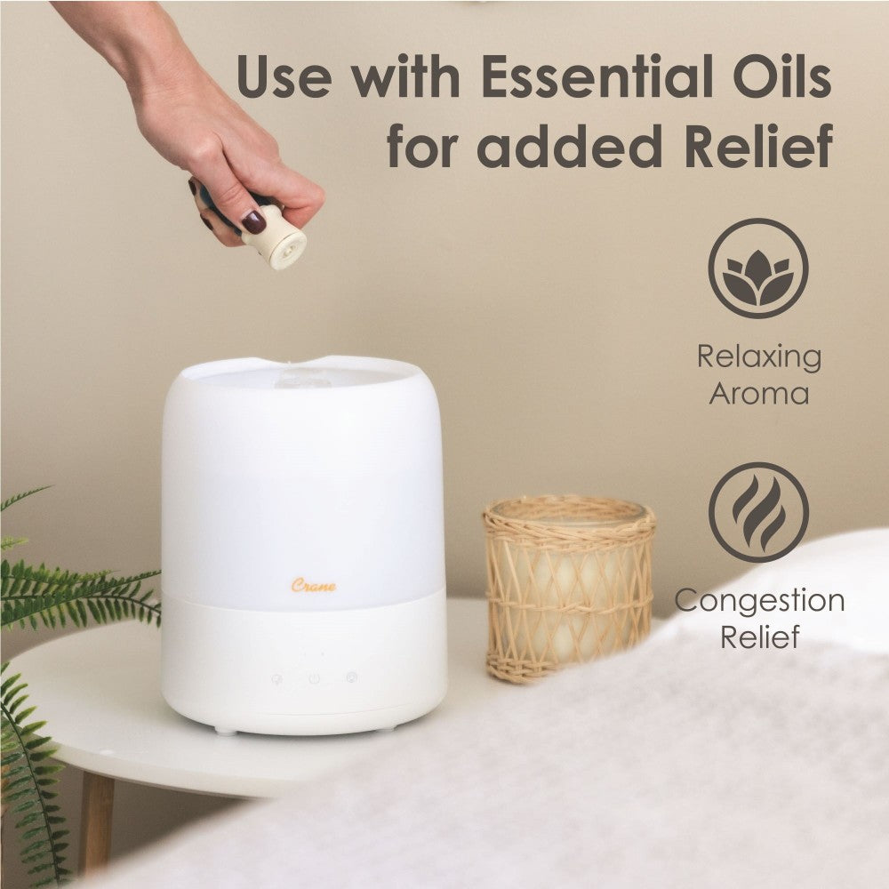 White Humidifier on a table with a hand adding essential oil, text about uses, and icons on a beige background.