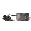 Black power adapter with coiled cable on a white background