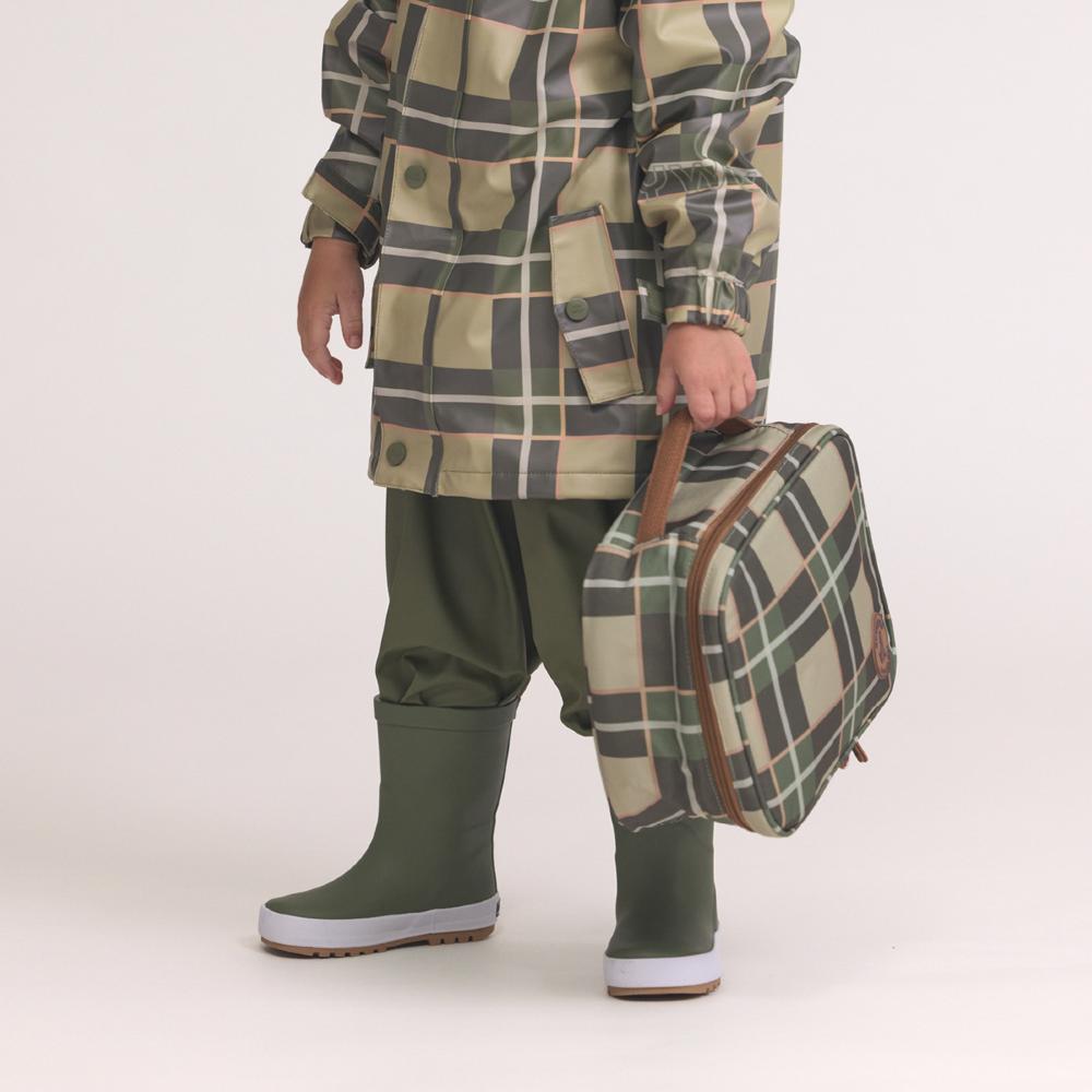 Person wearing a plaid raincoat and holding a matching plaid lunch bag on a white background