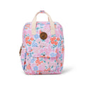 A backpack in a pink floral print with orange, blue, and green flowers, cream handles, and a brown circular logo patch on the front.