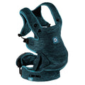 A baby carrier with a textured heathered teal blue fabric, featuring black plastic buckles and a small blue brand patch on the front.