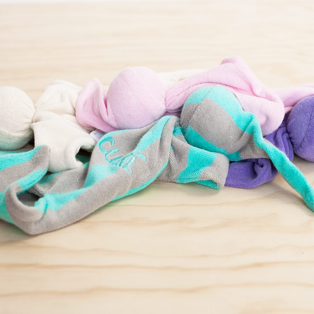 Assorted coloured Cuski comforters on a wood panel background