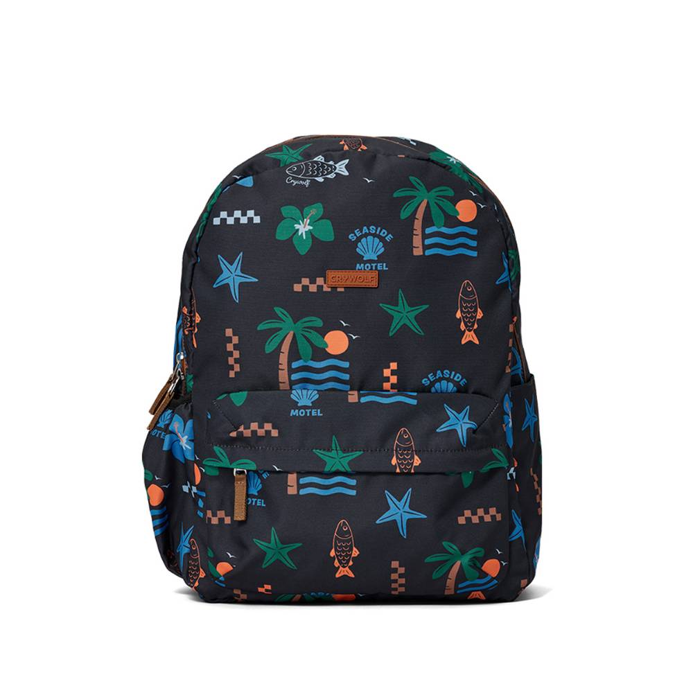 A black backpack with a colorful tropical beach print featuring palm trees, starfish, waves, and the words 'Seaside Motel'.