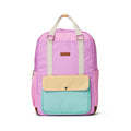 A pastel color-blocked backpack with a purple upper body, a mint green front pocket, and a pale yellow flap, featuring cream-colored top handles and a small brown brand patch.