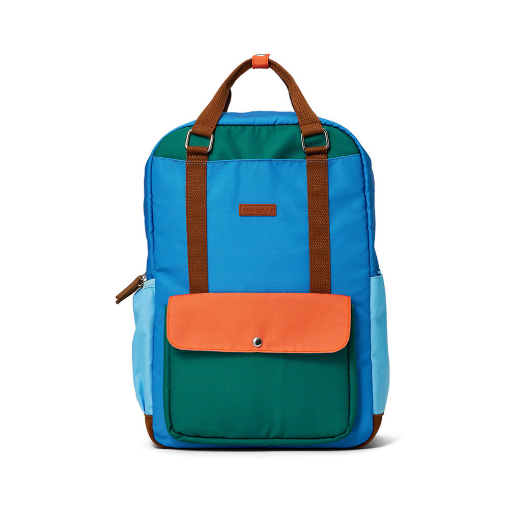 A color-blocked backpack with a bright blue body, teal green front pocket, orange flap, brown handles and straps, and light blue side pockets, shown on a white background.