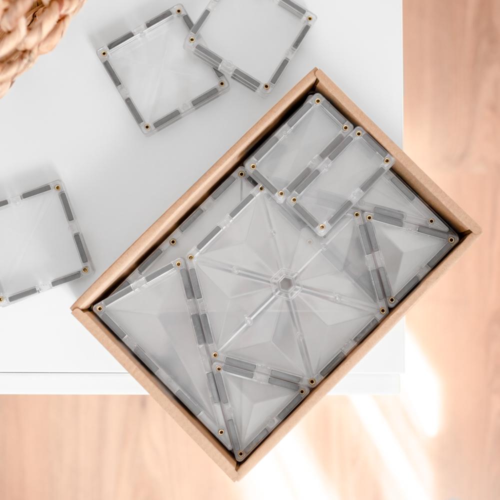 Clear geometric coasters in a wooden box on a light background