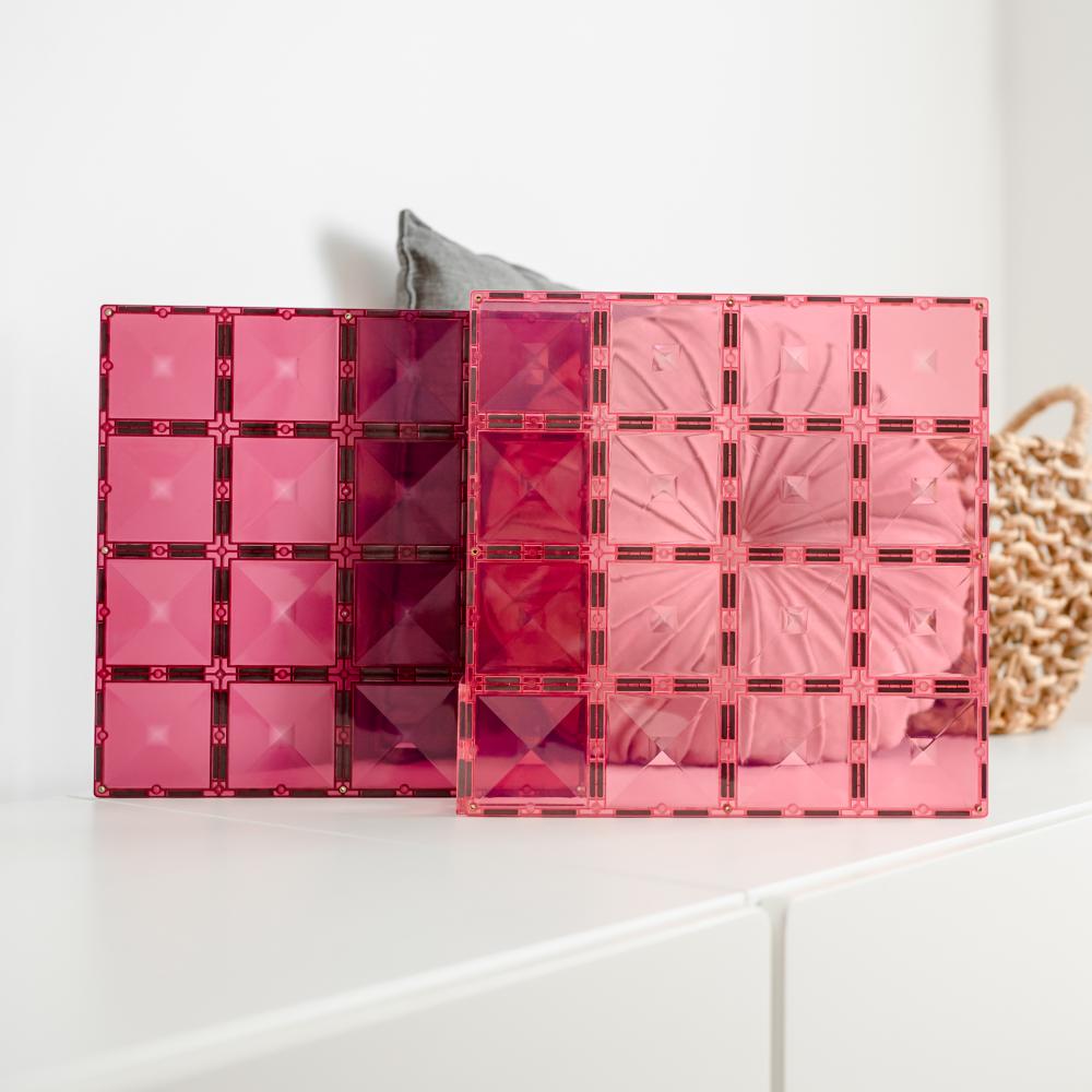 Pink transparent Connetix tiles with geometric design on a white surface