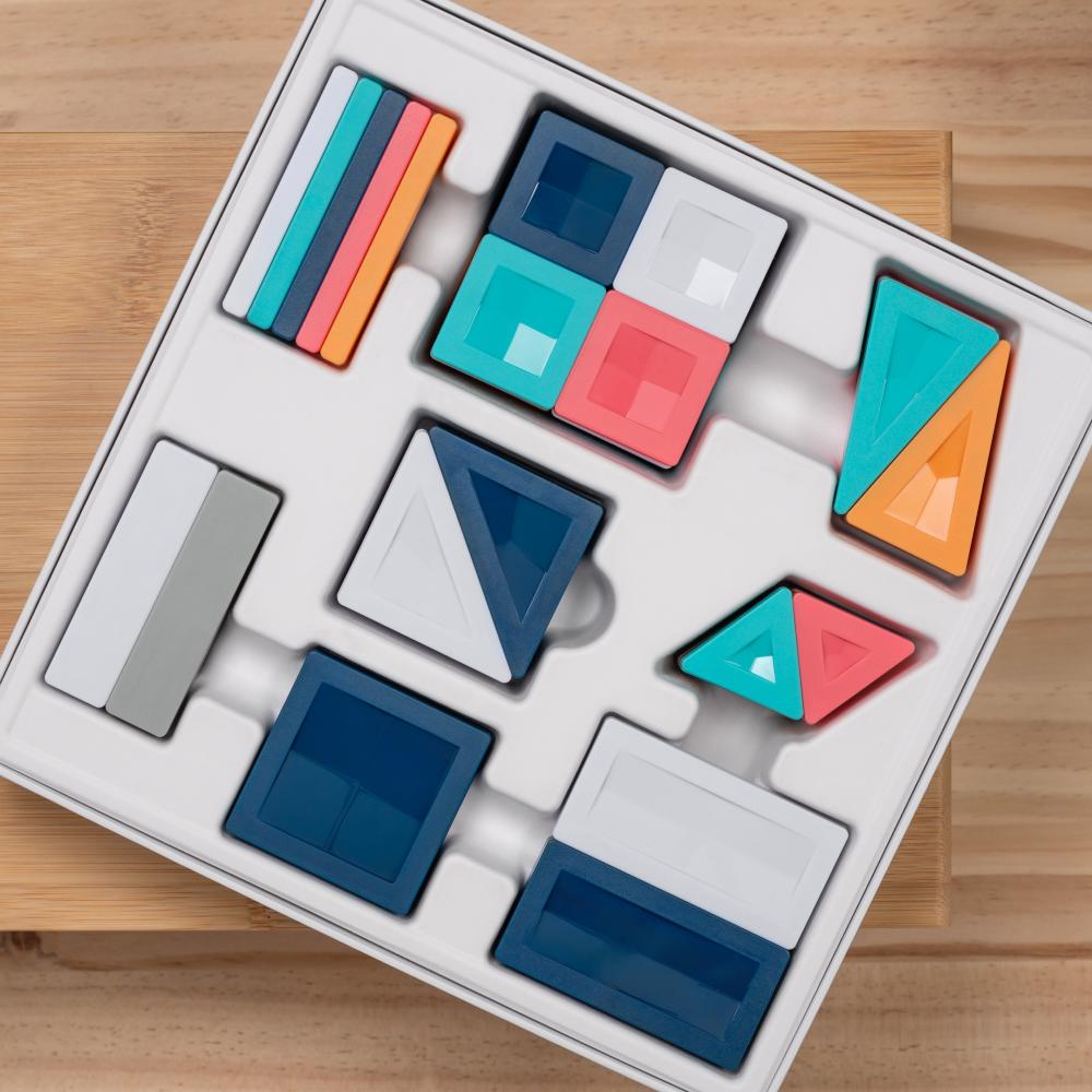 Colorful Connetix geometric building blocks in a box on a wooden surface