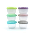 Six small round plastic storage containers stacked in two columns of three, each with a different colored lid: lime green, mint green, turquoise, lavender, blush pink, and dark gray. The containers are made of transparent plastic and are photographed on a clean white background.