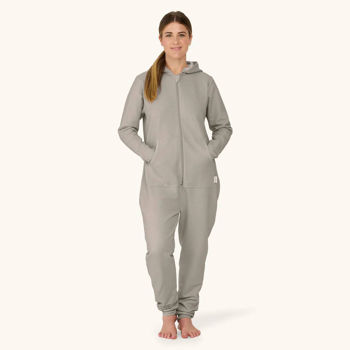 Woman wearing a gray onesie on a white background