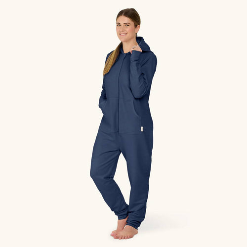 Woman wearing a navy blue breastfeeding onesie on a white background