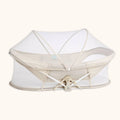 White and Beige portable bassinet with mesh cover