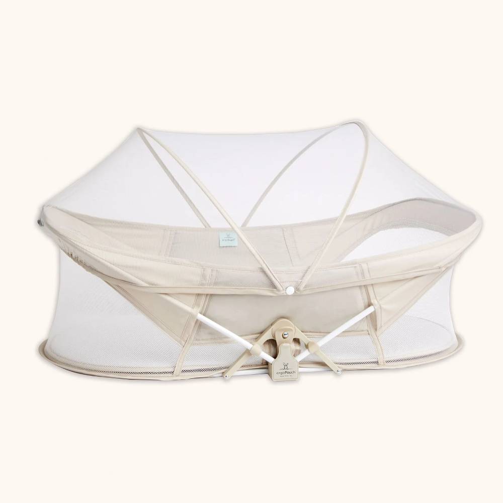 White and Beige portable bassinet with mesh cover