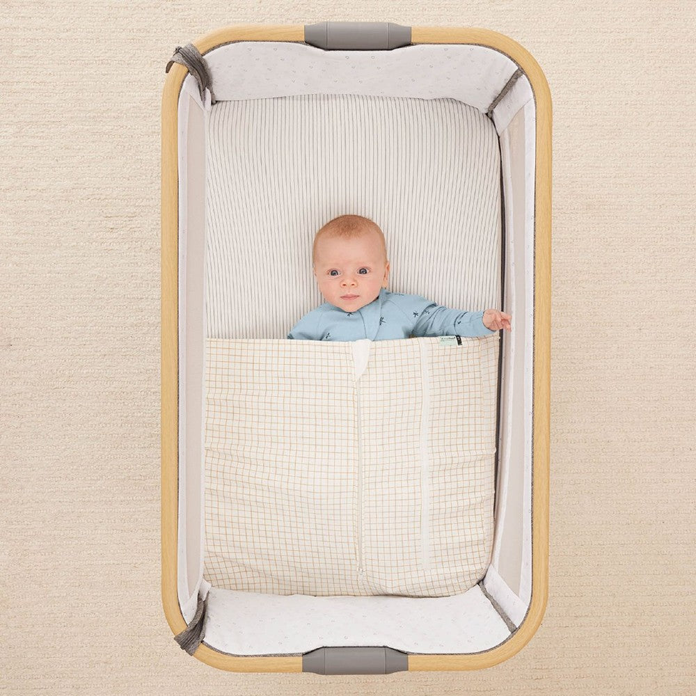 HugMe Blanket in Caramel grid pattern on a mattress on white background