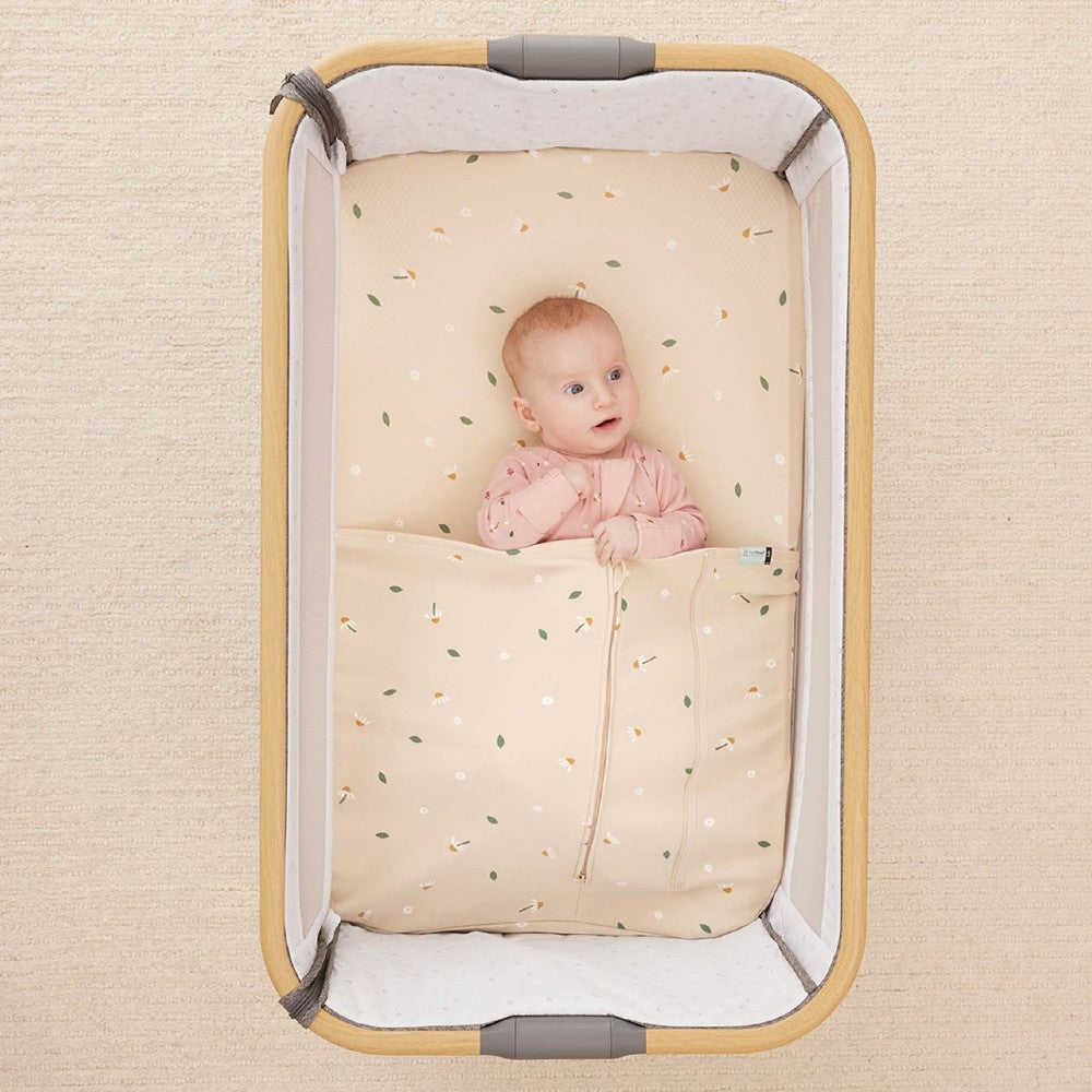 HugMe Blanket in Daisy Sprinkle pattern on a mattress on white background