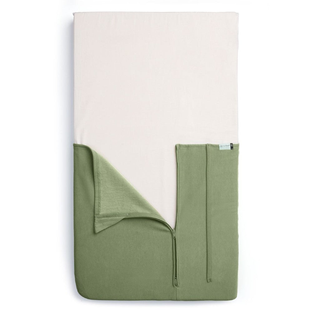 HugMe Blanket in Moss pattern on a mattress on white background