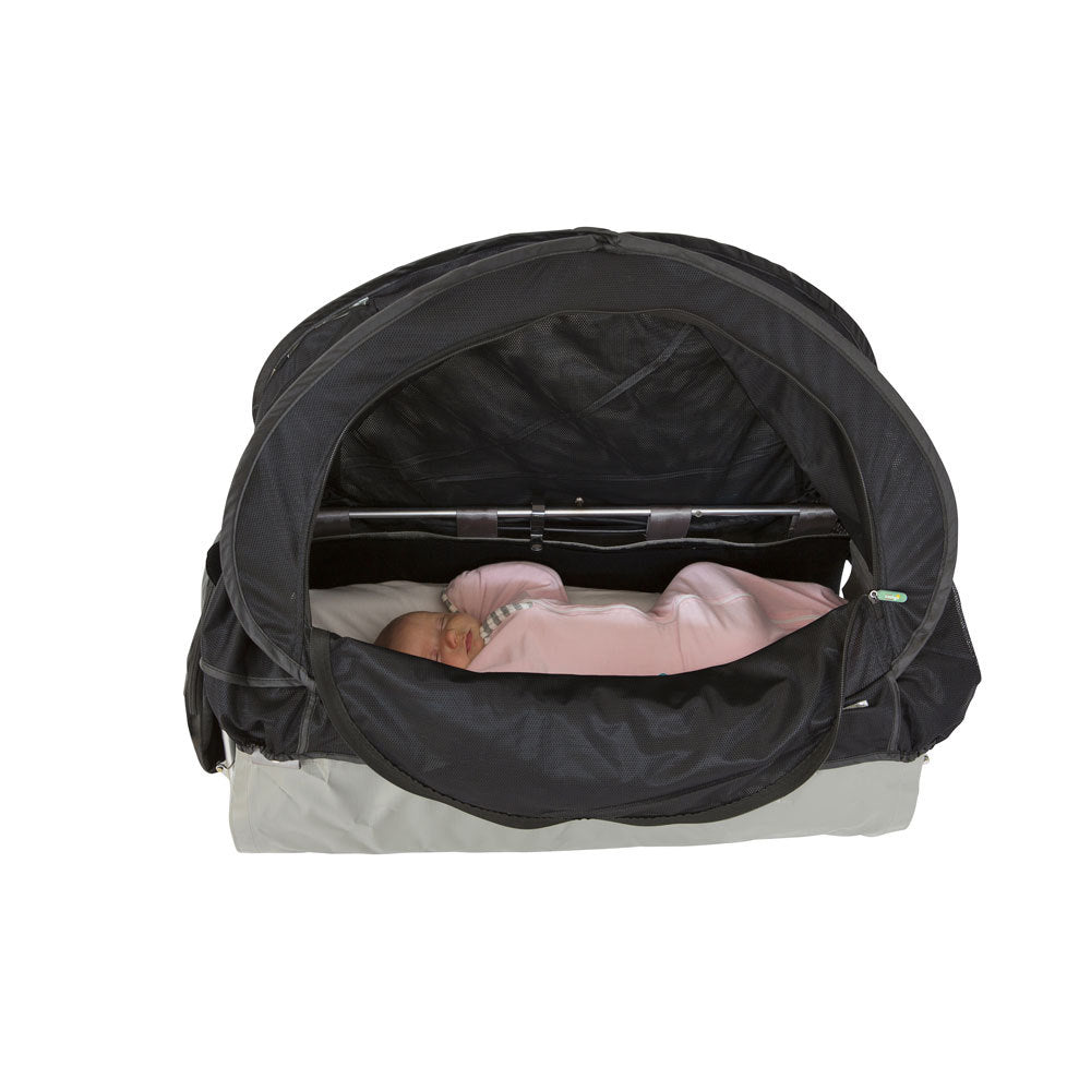 A black baby travel seat bassinet with a pop-up canopy, shown with a baby lying inside wearing a pink outfit. The bassinet has a black canopy and a light gray base, photographed against a solid white background.