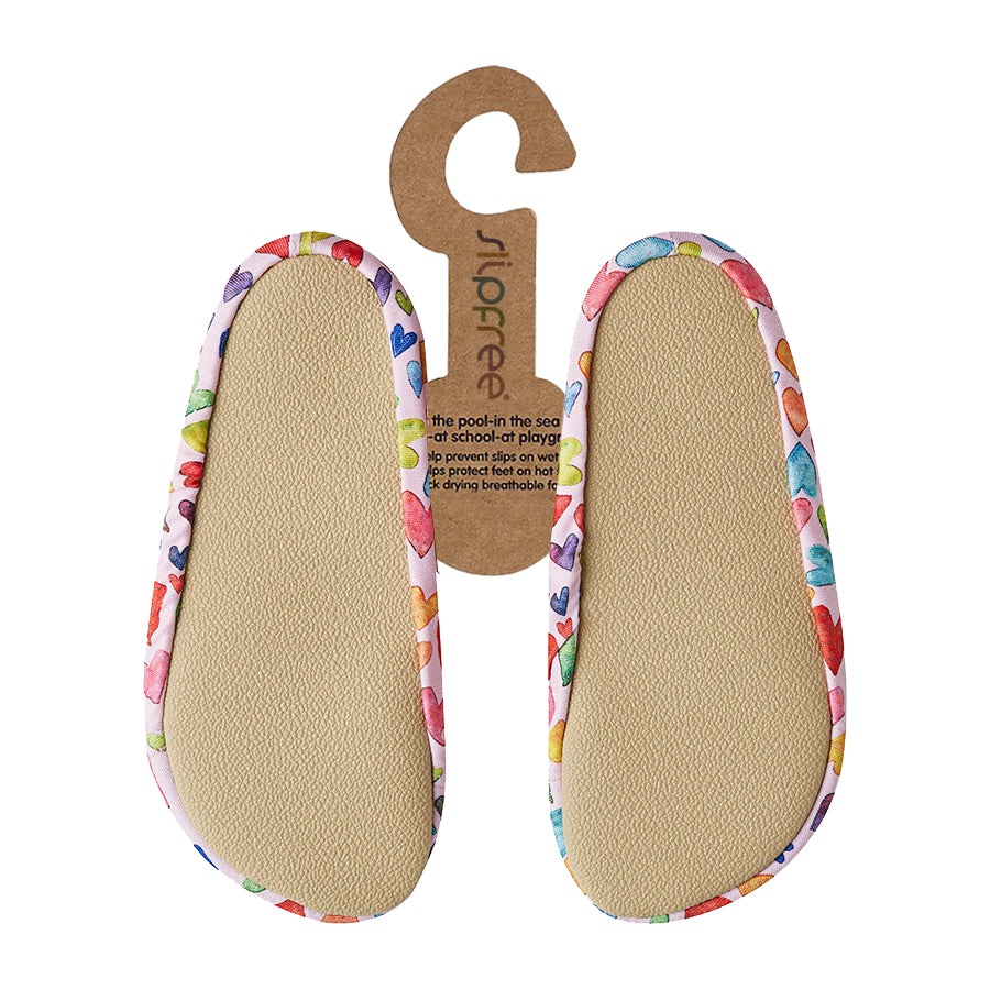 Pair of beige shoe inserts with colorful heart pattern on a white background