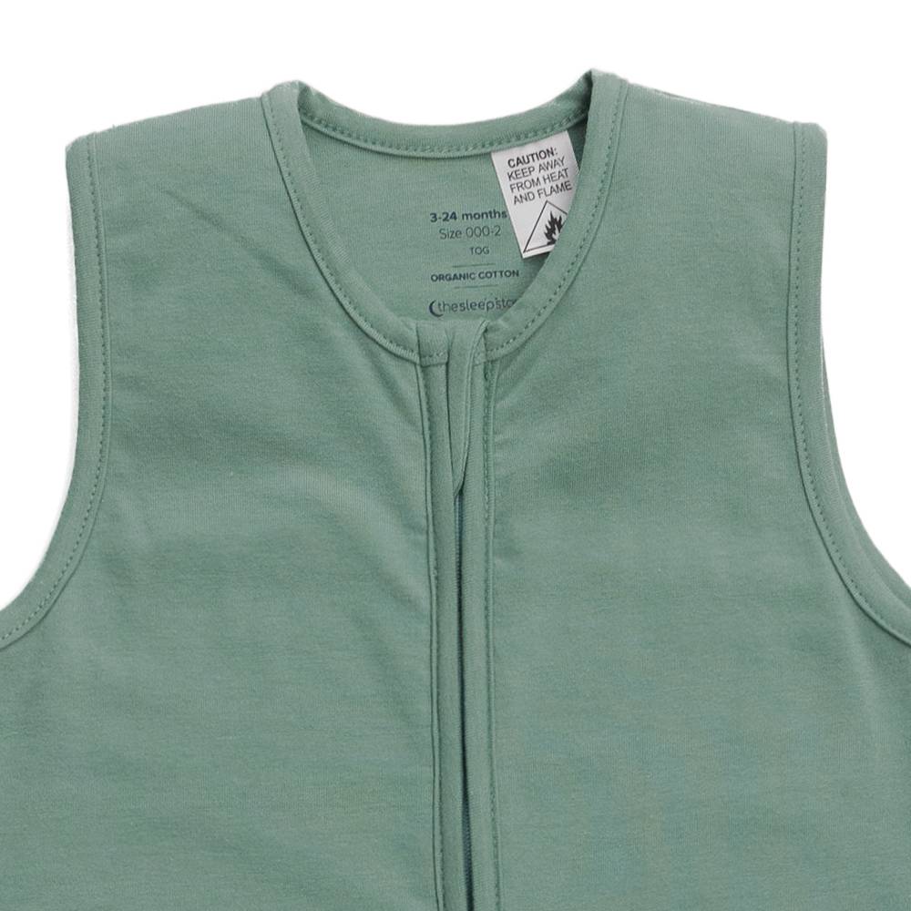 Green sleeveless baby garment with a close-up of the zipper and label on a white background