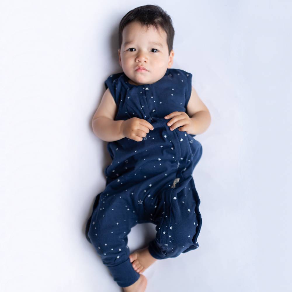 Child wearing a navy blue outfit with star patterns on a white background