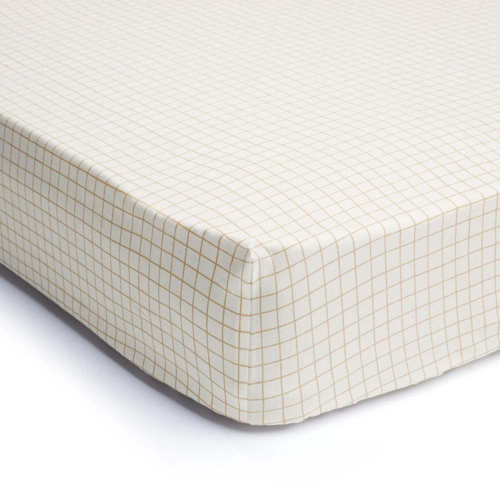 A waterproof fitted sheet shown on a mattress in Caramel Grid pattern