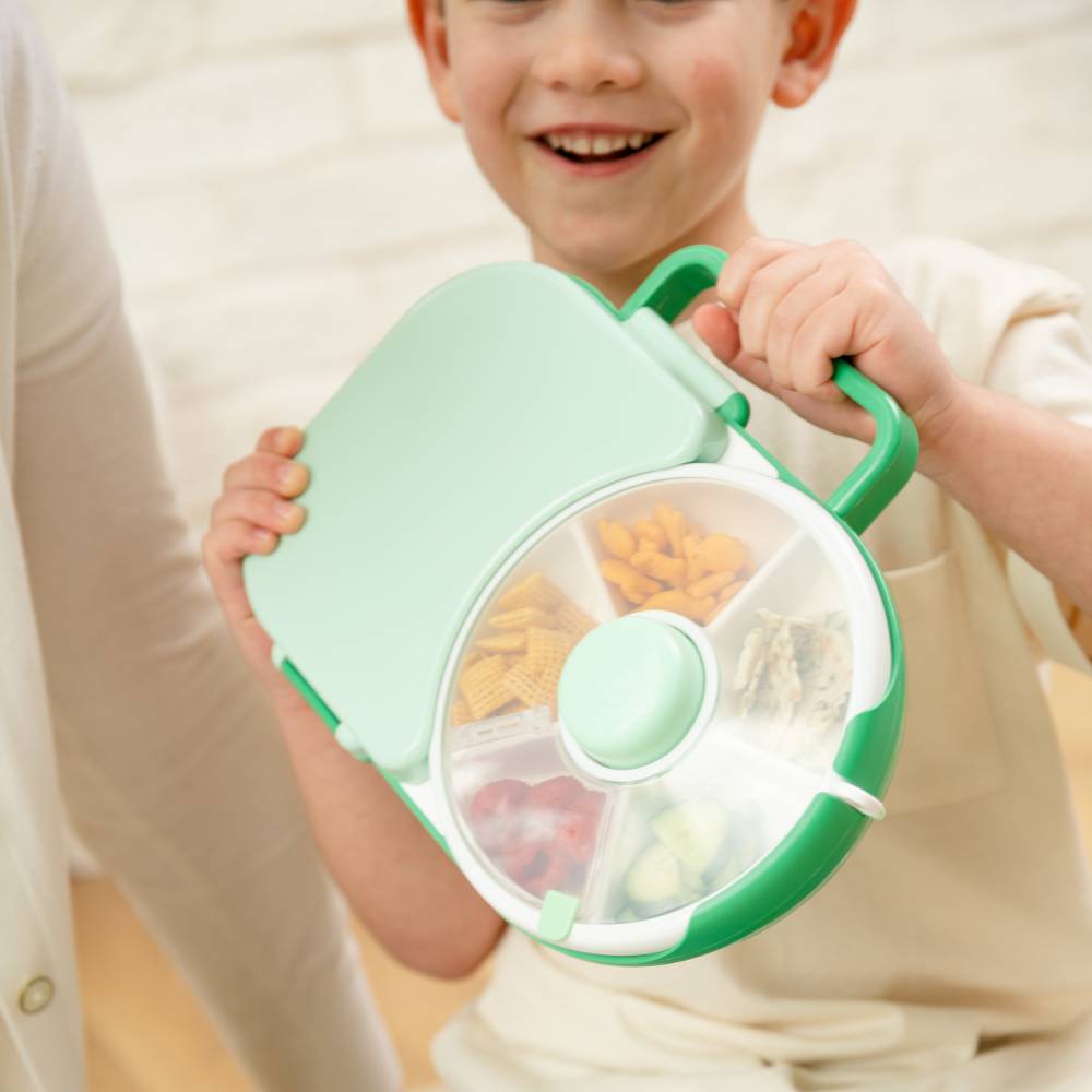 Child holding green Gobe lunchbox.