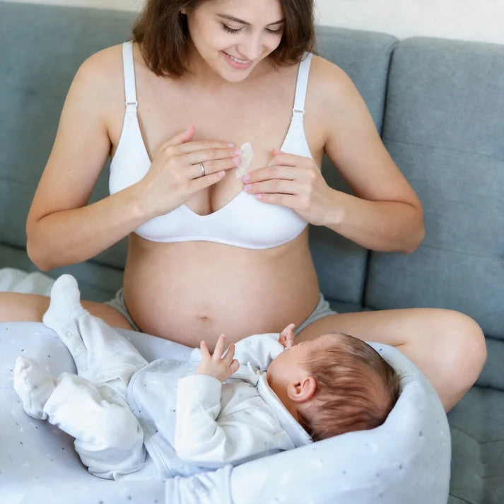 A mum applying Cabbage Extract Nursing Cream to her breast. 