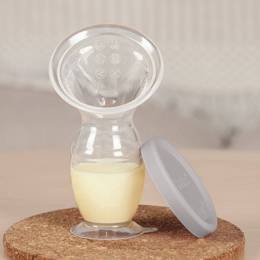 manual breastpump with milk inside and cap on the side 