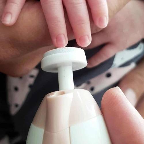 close up of baby hand with electric nail trimmer 