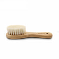Rubberwood and goats wool baby hairbrush against a white background