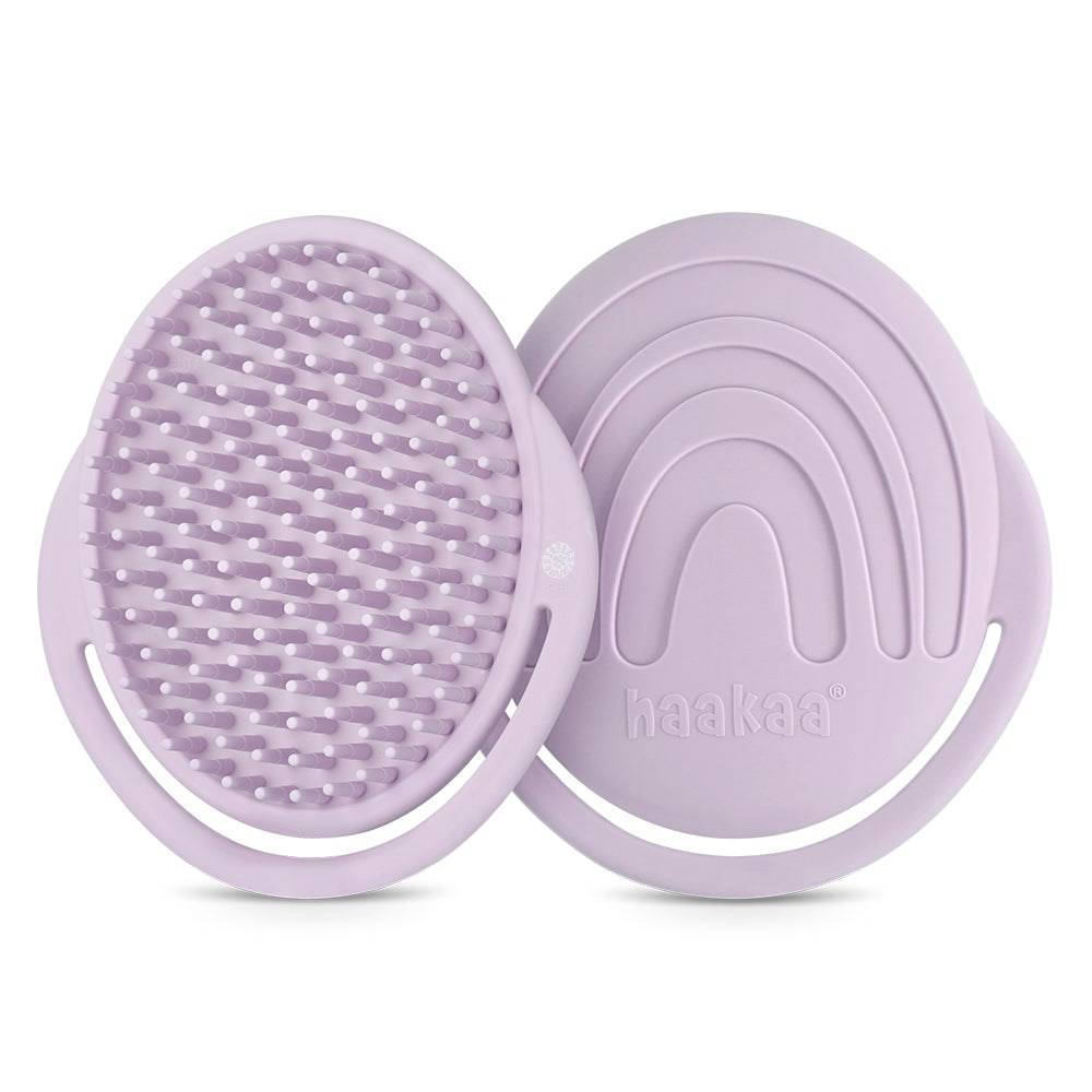 Lilac coloured silicone shampoo brush with soft bristles on a white background 