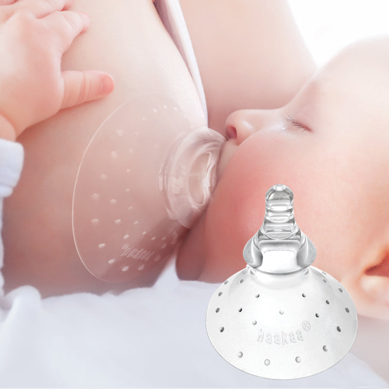 Baby using silicone nipple shield while feeding 