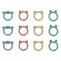 Twelve small ring-shaped baby teething toys arranged in a 3-by-4 grid on a white background. Each ring has a different animal face or ear design and comes in teal, peach, and pale yellow colors.