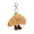 Brown Jellycat coissant bag charm against white background.
