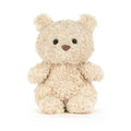 Small cream coloured Jellycat stuffed bear toy against white background.