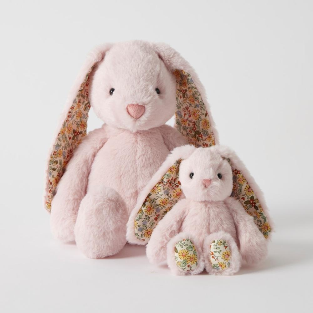 Two pink plush bunny toys with floral ears on a light gray background