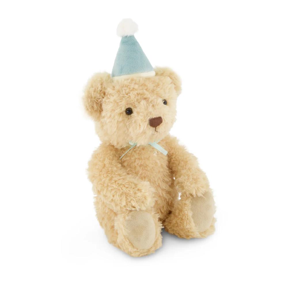 Jamie Kay brown bear soft toy with blue hat on against white background.